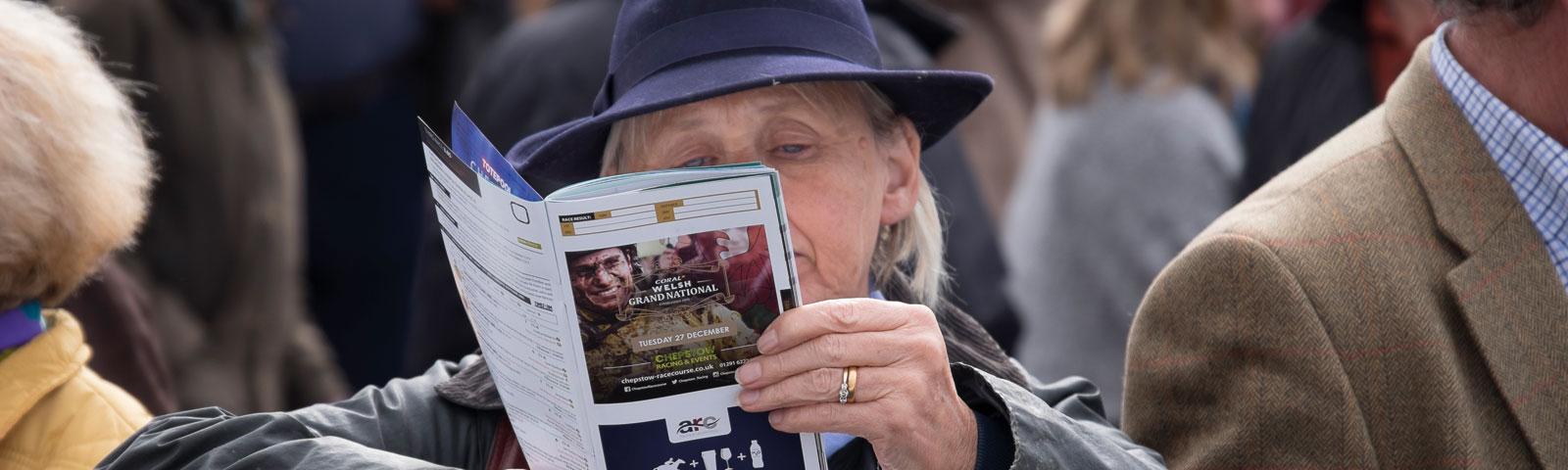 A racegoer looks through the days programme.