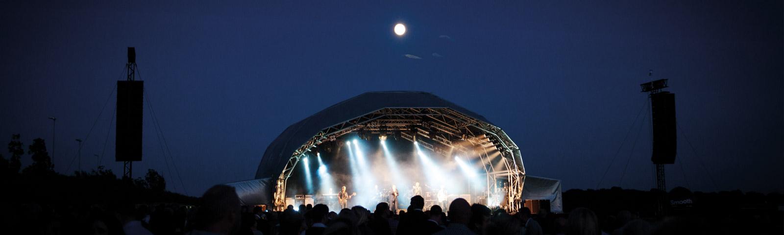 A view of the stage from deep within the crowd at night.