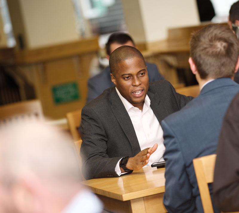 Two men having a conversation at a table.