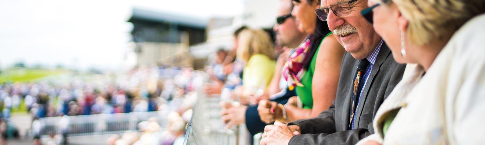 Crowds watching racing from a grandstand,