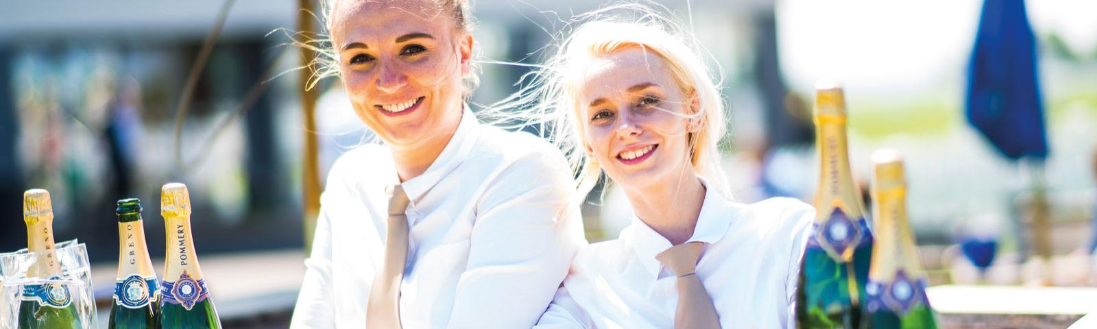 Racecourse staff outdoors in the sunshine preparing the drinks.