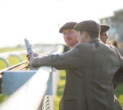 Two men standing next to track.