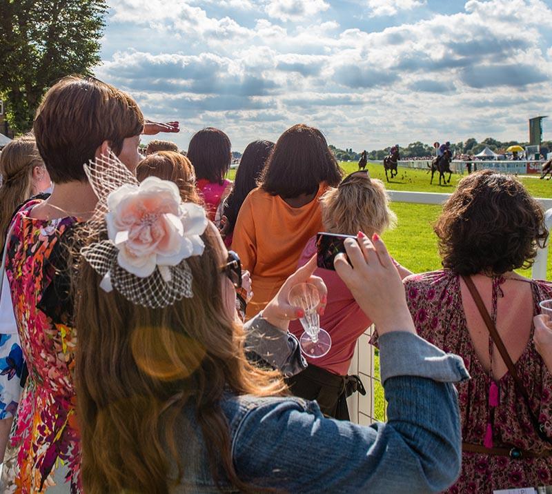 Group of ladies watching racing action.